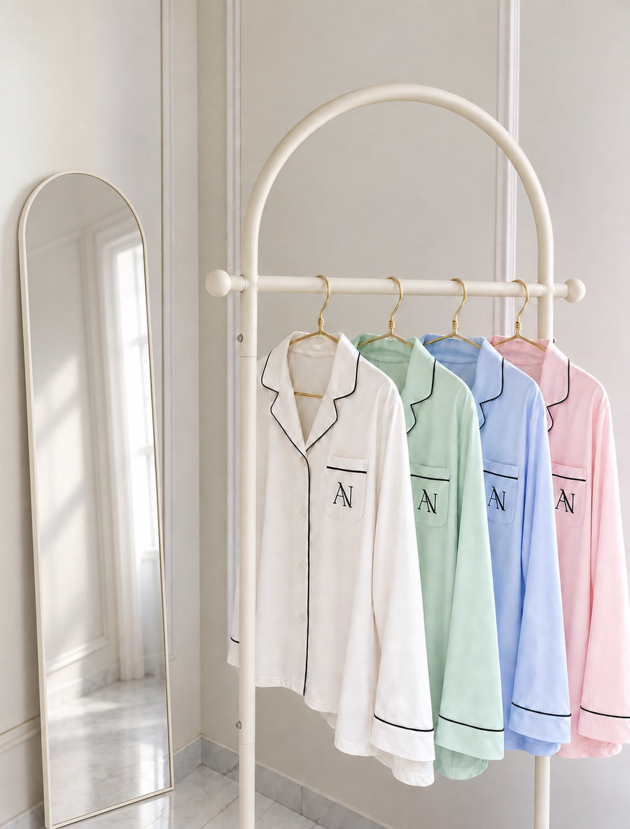 Bamboo Long Pyjama Set in Pearl, Mint, Blue Haze and Blush on an ivory rail beside a mirror.