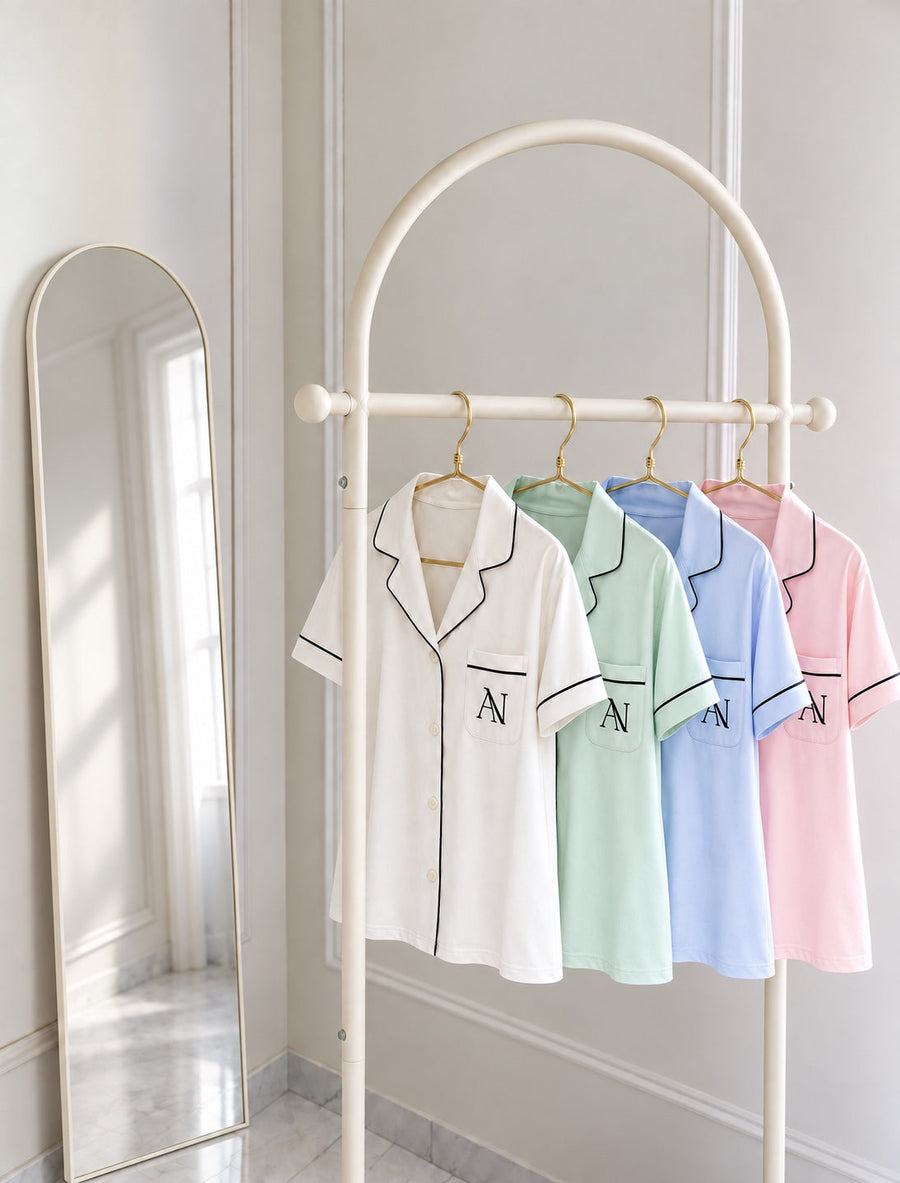 Bamboo Short Pyjama Set in Pearl, Mint, Blue Haze and Blush on an ivory rail beside a mirror.
