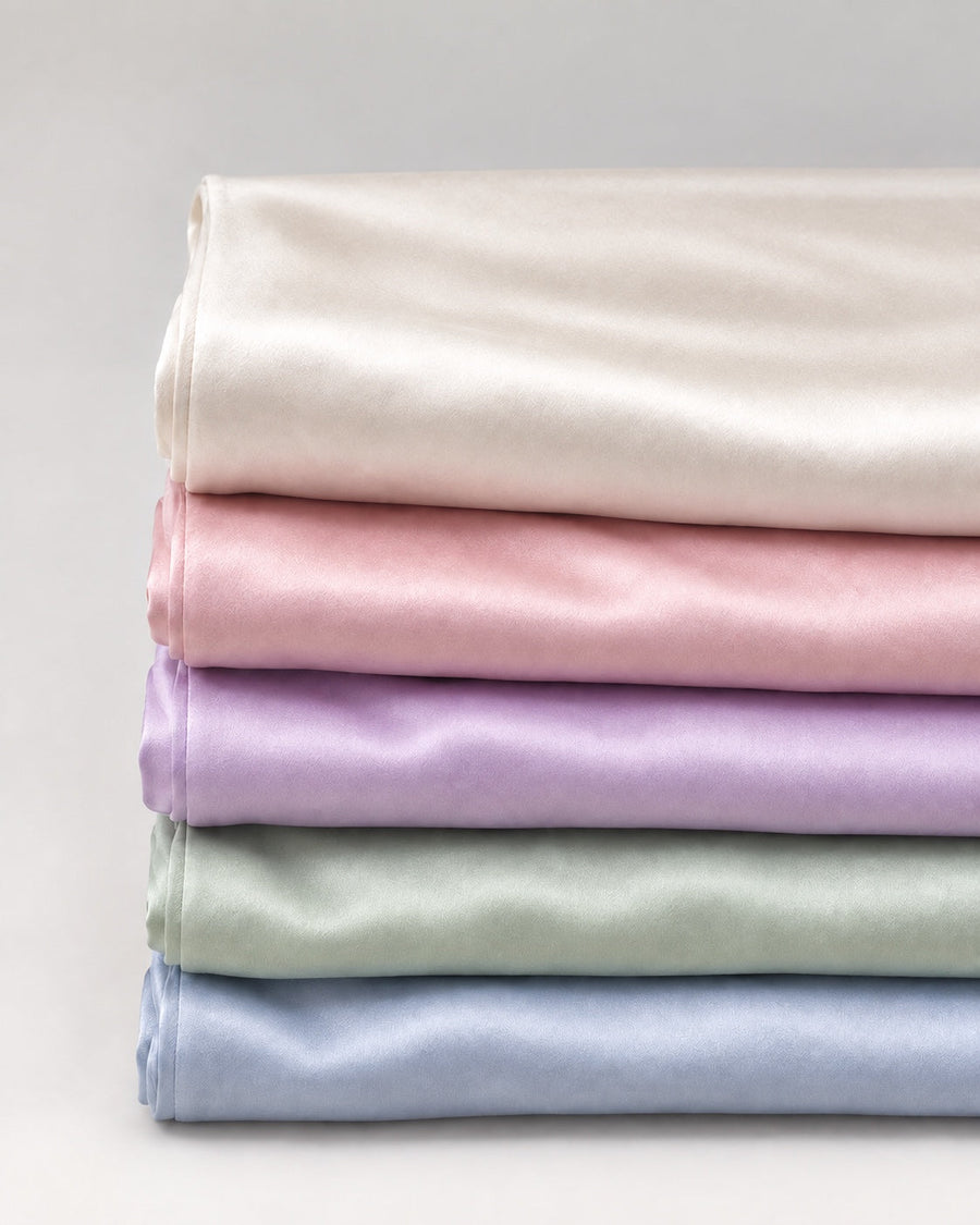Standard mulberry silk pillowcase in Pearl, Blush, Periwinkle, Mint and Blue Haze, folded in an even stack.