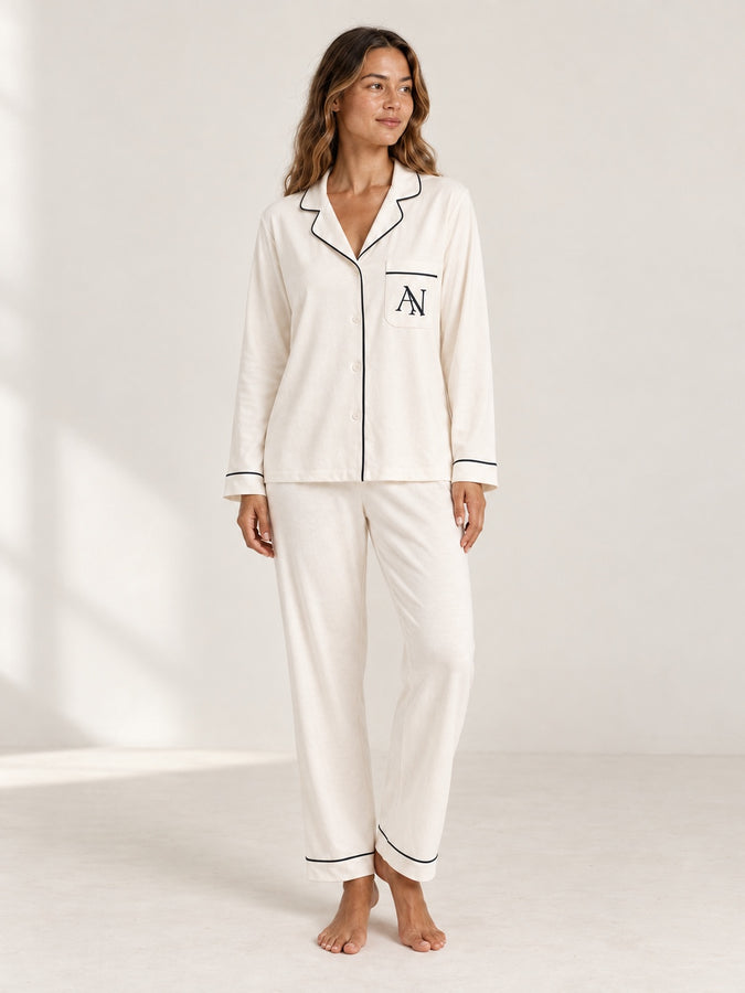 Shoulder-down view of the Pearl bamboo long pyjama set with black piping and the intertwined AN pocket monogram