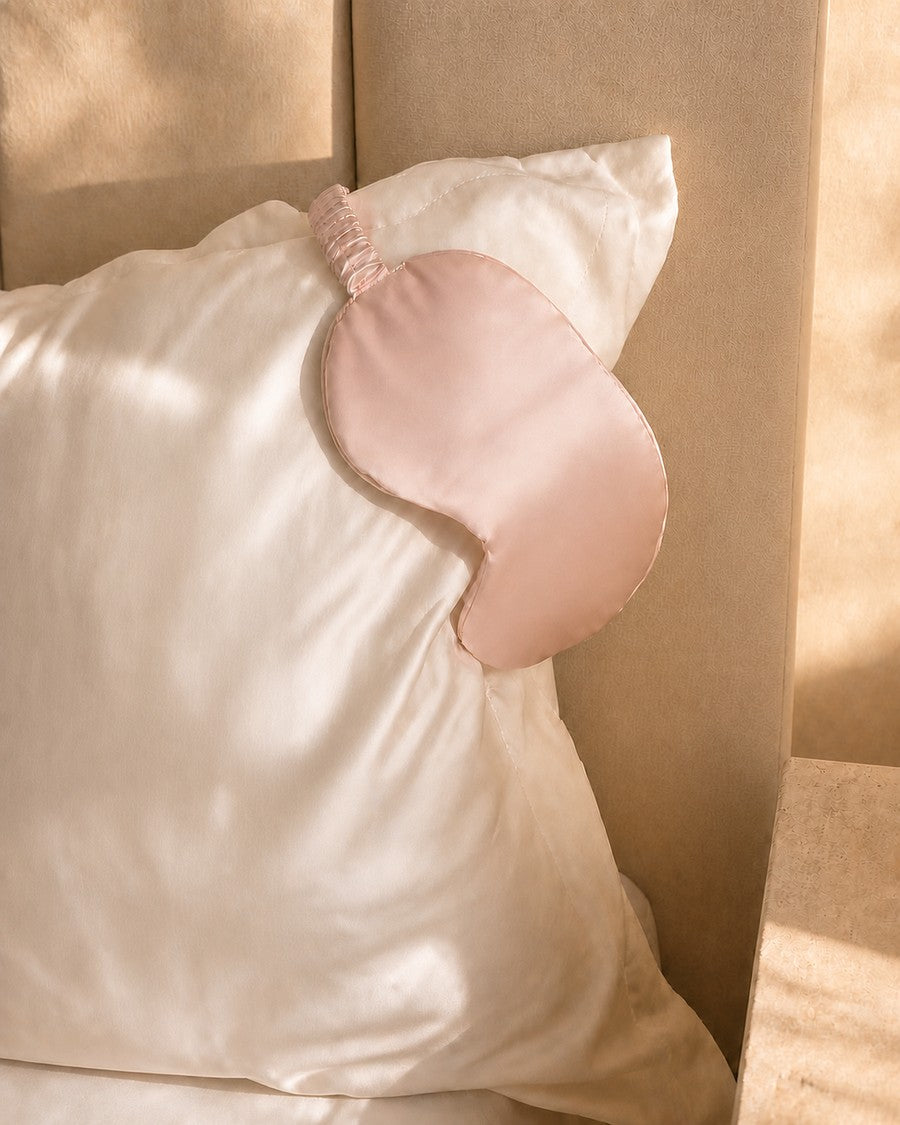 Plain blush mulberry silk eye mask on an ivory silk pillowcase